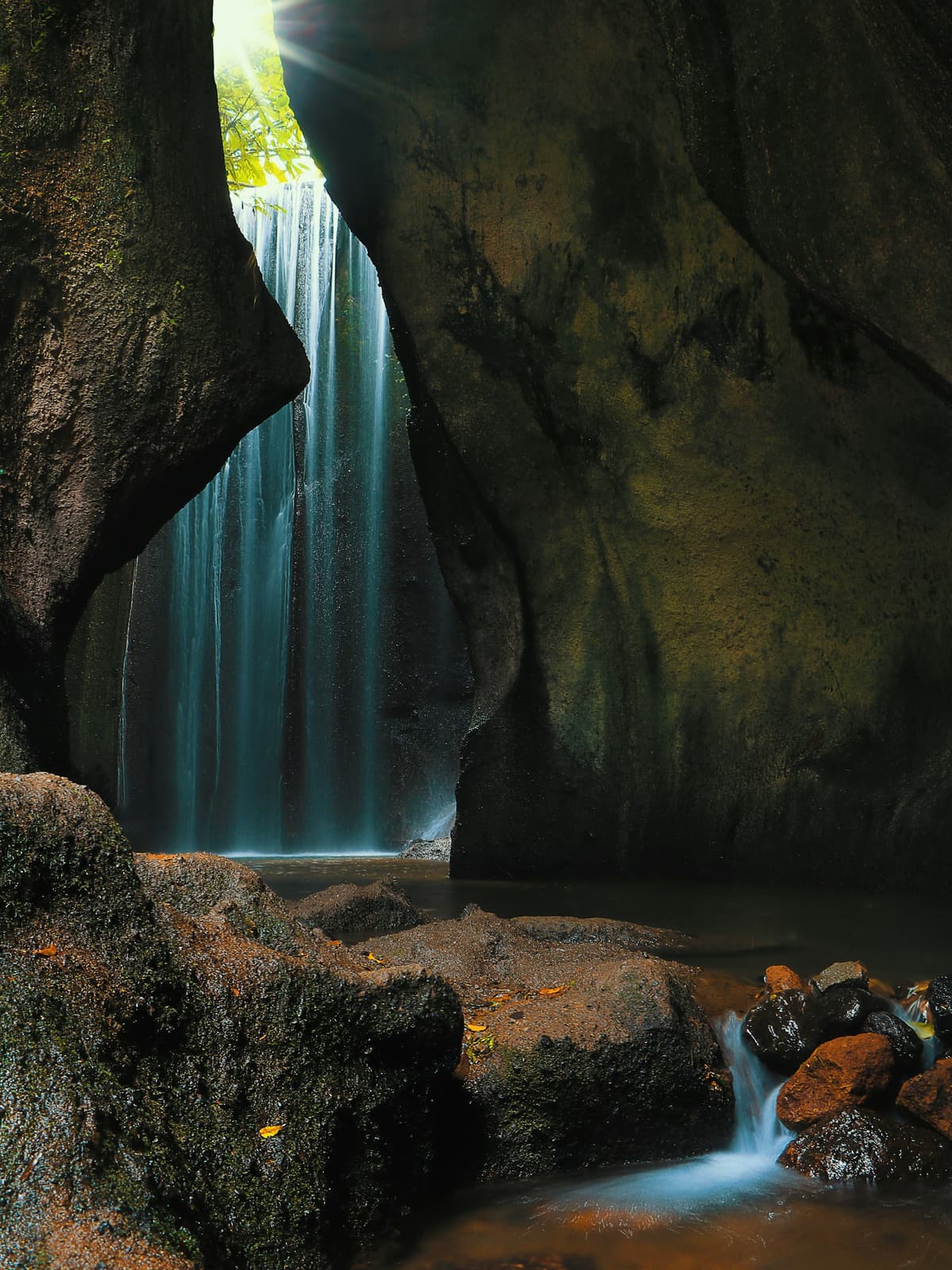 Sunlight streaming through Tukad Cepung waterfall cave